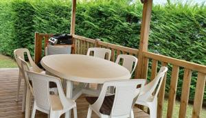 a white table and chairs on a deck at Les Charmettes - SIBLU in Les Mathes