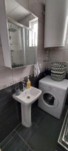 łazienka z umywalką i pralką w obiekcie Mario apartment w mieście Strumica