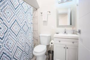 ein Badezimmer mit einem WC, einem Waschbecken und einem Spiegel in der Unterkunft Luxurious One Bedroom Suite with Balboa Park View in San Diego