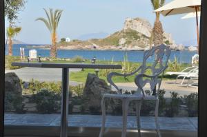 a table and chair with a view of the water at Royal Bay Suites in Kefalos