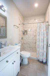a white bathroom with a toilet and a sink at Studio with Beautiful View next to Downtown in San Diego +24 photos