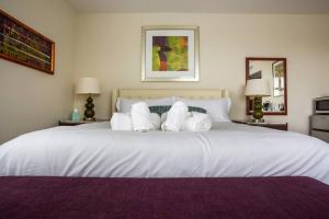 um quarto com uma grande cama branca com almofadas em Modern, Luxurious and Prime location All in One em San Diego