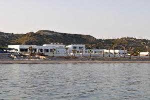 a group of white buildings on a beach next to the water at Royal Bay Suites in Kefalos