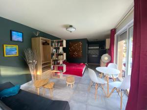 uma sala de estar com um sofá, uma mesa e cadeiras em Logement 2/4 pers-piscine-25mn rocade bordeaux em Baron