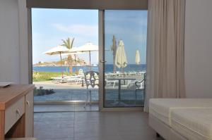 a bedroom with a bed and a view of the ocean at Royal Bay Suites in Kefalos