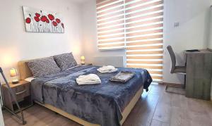 a bedroom with a bed with two towels on it at Apartmani Lavanda in Soko Banja