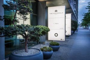 a row of potted trees in front of a building at The Mandala Hotel in Berlin