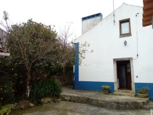 une maison blanche et bleue avec une porte dans l'établissement Casas Altas Obidos - AL, à Sobral
