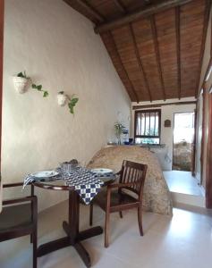 Una sala de estar con una mesa y una cama. en Refúgio Guest House, en Ilhabela