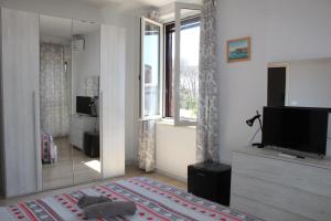 a living room with a television and a large mirror at Il giardino del casciar in Castel Volturno