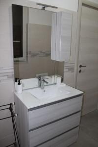 a bathroom with a white sink and a mirror at Il giardino del casciar in Castel Volturno +44 photos