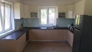 a kitchen with white cabinets and a black refrigerator at Hostel Hangout in Bar