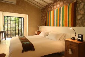 a bedroom with a large white bed and a window at Finca Adalgisa in Chacras de Coria