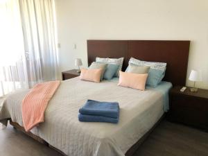 a bedroom with a large bed with a blue towel on it at 2 Bedroom Apartment , Hope Island , Resort living in Gold Coast