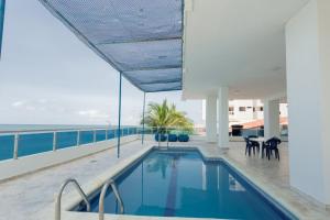 a swimming pool on the roof of a building with the ocean at APARTESTUDIO MARINARE DE 1 HABITACION CON SALIDA DIRECTA A LA PLAYA m in Cartagena de Indias