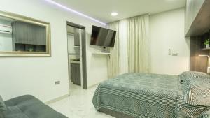 a hotel room with a bed and a couch at APARTESTUDIO MARINARE DE 1 HABITACION CON SALIDA DIRECTA A LA PLAYA m in Cartagena de Indias