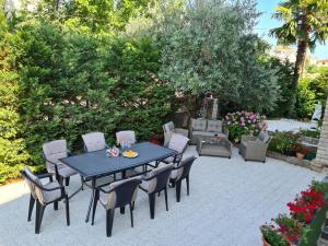 a patio with a blue table and chairs at Villa Rea in Malinska