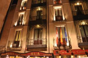 un bâtiment avec deux drapeaux sur son côté dans l'établissement Hotel Rua Salamanca, à Salamanque