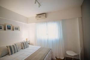 a white bedroom with a bed and a window at Recoleta White Home in Buenos Aires