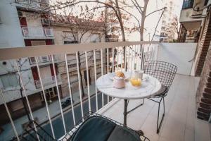 una mesa en un balcón con 2 vasos de zumo de naranja en Recoleta White Home en Buenos Aires