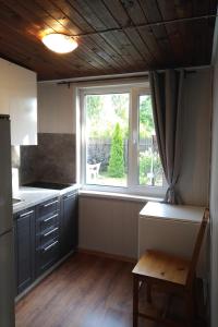 a kitchen with a large window and a table at Renovated wooden cottage 300 meters from the beach in Ragaciems