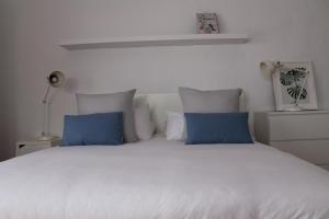 um quarto com uma cama branca e almofadas azuis em Casa Volcan De Gayria em Valles de Ortega