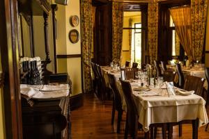 een restaurant met tafels en stoelen in een kamer bij Ballinalacken Castle Country House Hotel in Doolin