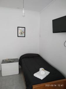 een slaapkamer met een bed met een zwarte deken en een tv bij ETXEA Alojamiento in Deán Funes