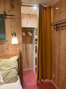 1 dormitorio con cama y cortina amarilla en La cour secrète, en Dinan
