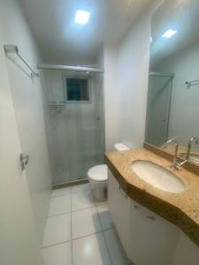 a bathroom with a sink and a toilet and a mirror at Apto 3 Quartos com Ar, Piscina, Garagem - Cuiabá in Cuiabá