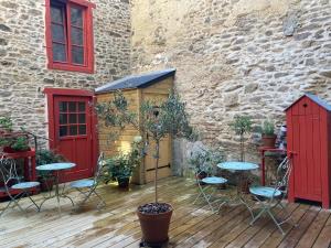 a patio with a table and chairs and a building at La cour secrète in Dinan