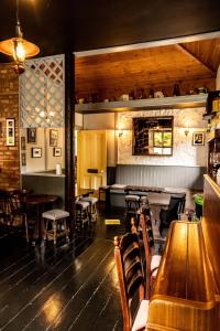 a restaurant with wooden tables and chairs and a bar at Ballinalacken Castle Country House Hotel in Doolin