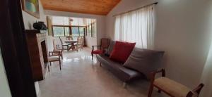 sala de estar con sofá y mesa en Hacienda Moncora cabaña lago p2, en El Rosal