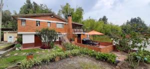una imagen de una casa con jardín en Hacienda Moncora cabaña lago p2, en El Rosal