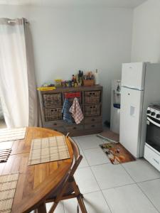 a kitchen with a wooden table and a refrigerator at BUNGALOW PAMATAI in Faaa
