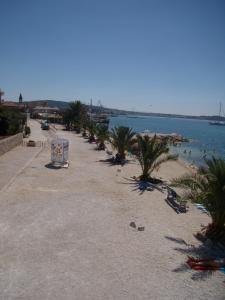 una playa con palmeras y un cuerpo de agua en Stari Dvori, en Trogir