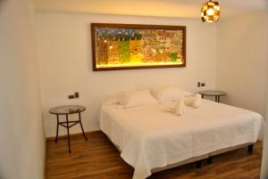 a bedroom with a white bed and two tables at Hotel Boutique Casona Violeta in San Carlos