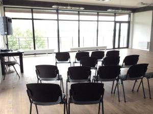 a room with chairs and a table and windows at Ūdens Tūrisma Attīstības Centrs Bāka in Gaigalava