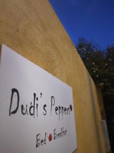 a sign on a wall in front of a building at Dudi's Peppers in Málaga