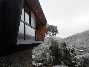 a house with a window on the side of it at NIDO ARRIBA CABAÑAS in Villa la Bolsa