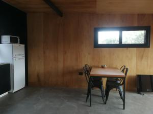 a kitchen with a table and chairs and a refrigerator at NIDO ARRIBA CABAÑAS in Villa la Bolsa +6 photos