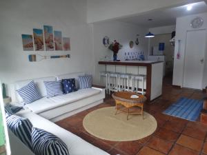a living room with a white couch and a table at VIVA BUZIOS no Condominio Aqua Marina casa3 in Búzios