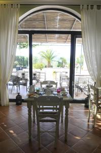 a table and chairs in a room with a large window at Poggio di Luna Adults Only in Peschici