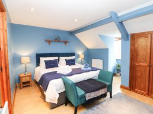 um quarto azul com uma cama e uma cadeira em Langlands em Barnard Castle