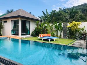 a swimming pool with a bench next to a house at Villa MAI MEE PAN HA 3 bedrooms in Nai Yang Beach