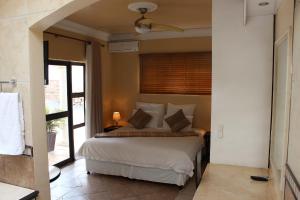 a bedroom with a large bed with a window at Almost Heaven in Durban