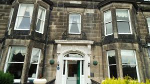 an old brick building with a white door at Alexander Guest House in Edinburgh
