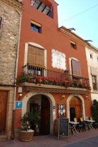 a building with a balcony with flowers on it at Hostal Populetus in Poboleda