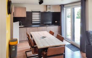 - une cuisine avec une table et des chaises en bois dans l'établissement 3 Bedroom Nice Home In Heinkenszand, à Heinkensand