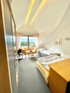 Cette chambre comprend 2 lits et une table. dans l'établissement Hotel Pension Linz, à Buhl